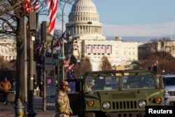 U.S. National Guardsmen patrol on the Pennsylvania Avenue with the Capitol Hill in the background, ahead of the presidential inauguration of President-elect Donald Trump, in Washington, Jan. 18, 2025.